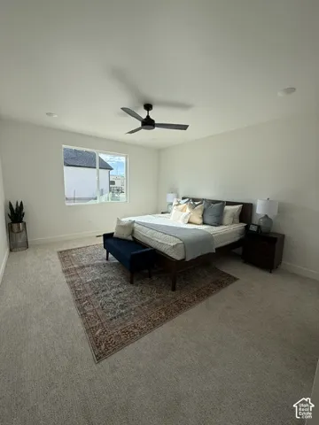 Light-colored carpeted flooring, white painted walls, black ceiling fan with integrated lighting, recessed lighting, and a large window