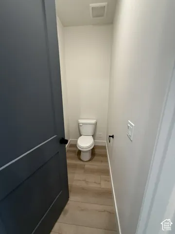 Recessed lighting, wood-finish flooring, and white walls