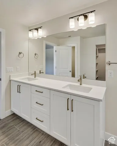 Dual vanity with undermount sinks, white cabinetry, and brushed nickel hardware