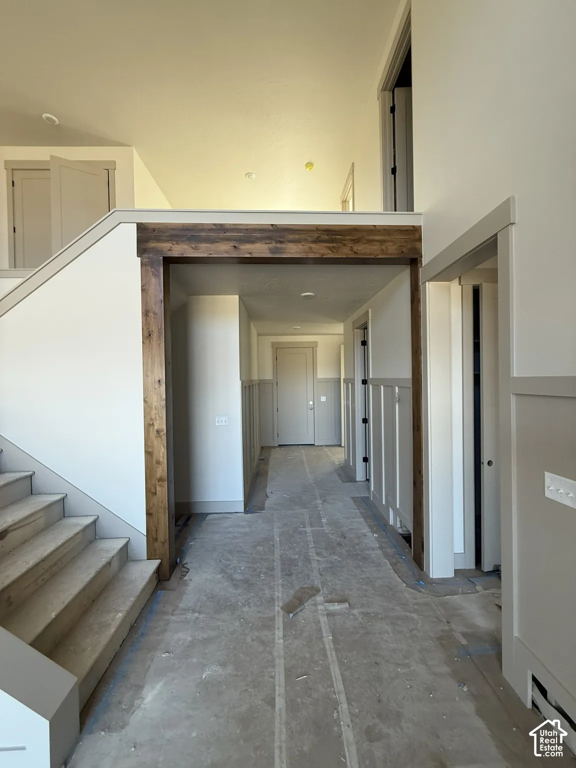 Interior featuring a structural timber header, board and batten wainscoting, and a staircase with wood-finish treads