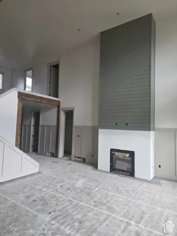 Floor-to-ceiling fireplace feature wall with decorative horizontal wood paneling, wood-beam header, board-and-batten wainscoting, and recessed lighting