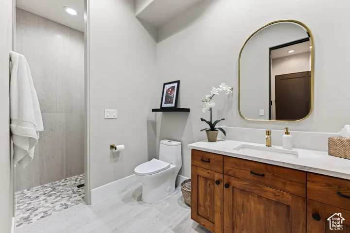 2nd Bathroom: Spacious bathroom featuring a walk-in shower with mosaic tile flooring, a single vanity with a wood-finish cabinet, a white countertop, and a contemporary mirror
