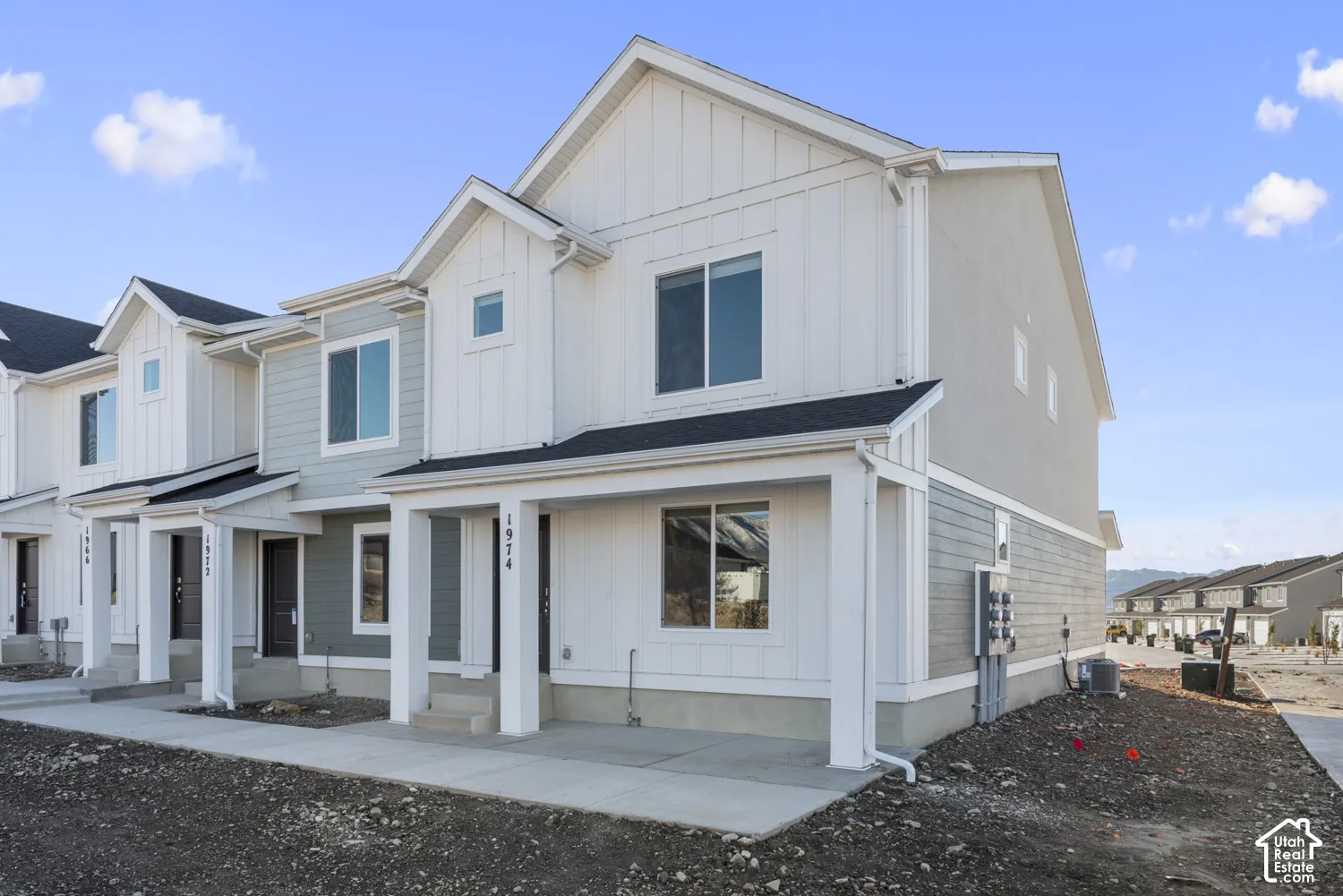 Contemporary townhouse exterior featuring board and batten siding, horizontal siding, and a covered porch
