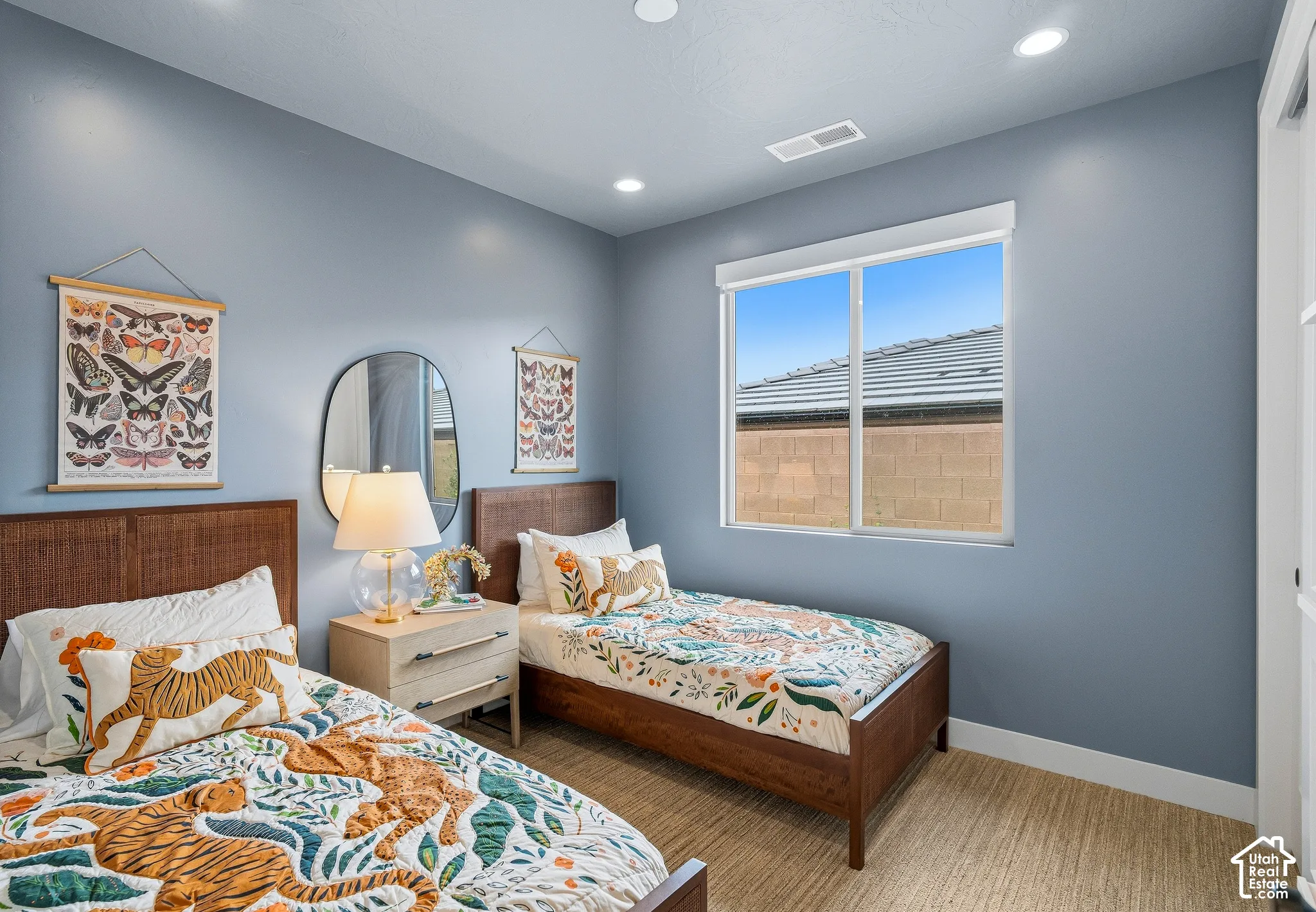 Recessed ceiling lighting, light blue wall paint, wood-finish flooring, white trim, and a white framed window