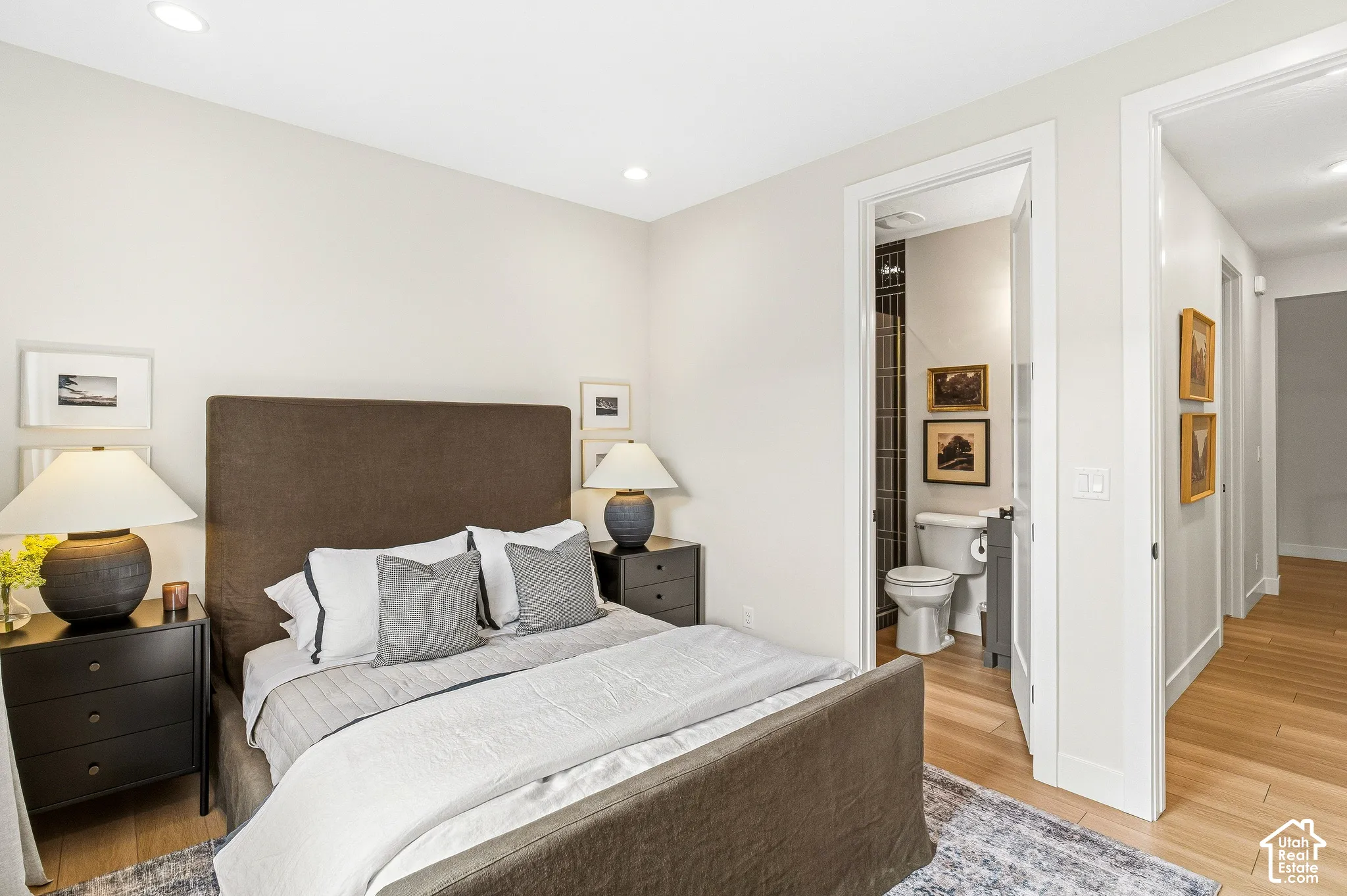 Recessed lighting, wood-finish flooring, attached bathroom with tiled wall, built-in shelving, and white walls