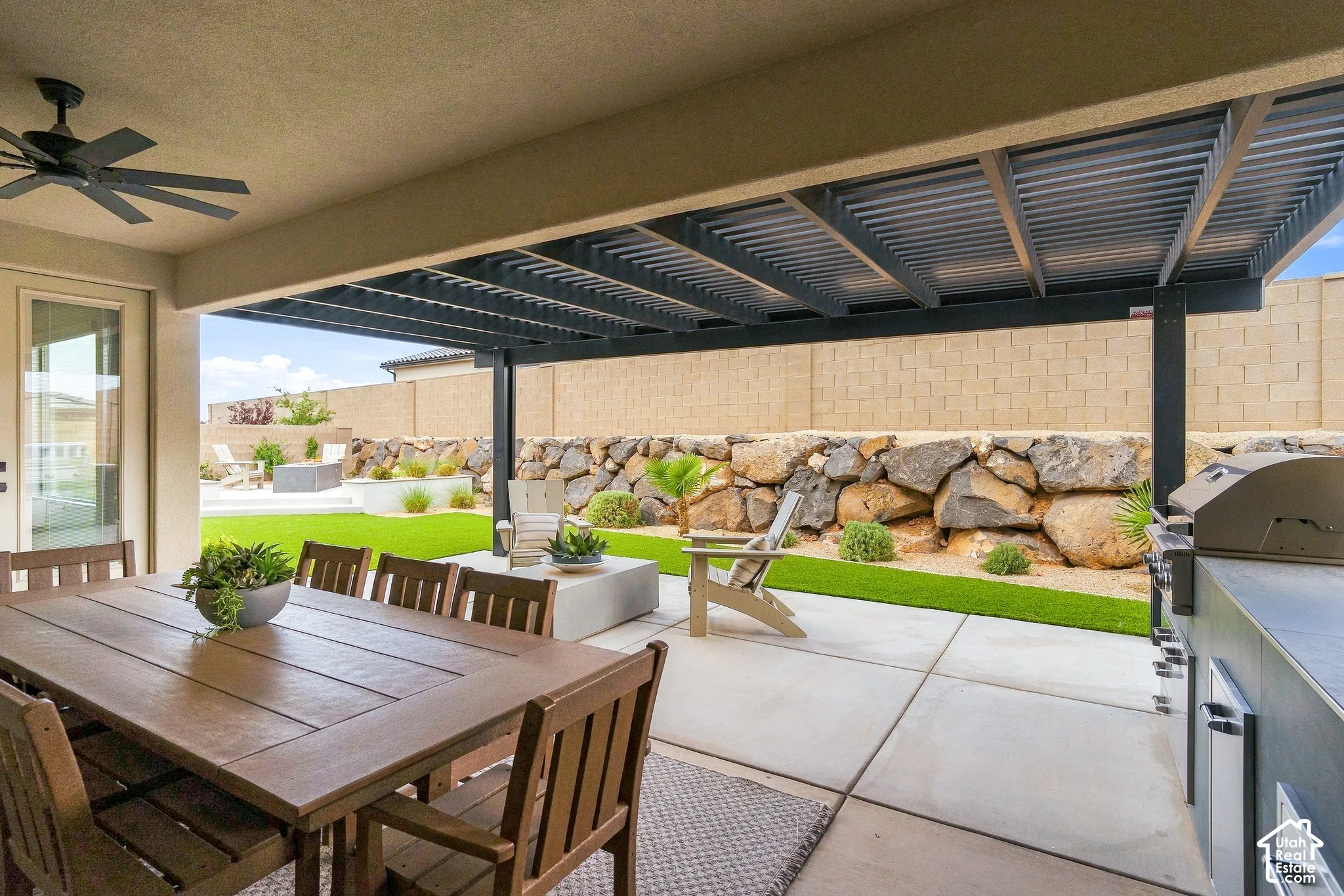 Covered patio with a ceiling fan, concrete paver flooring, and an outdoor built-in grill