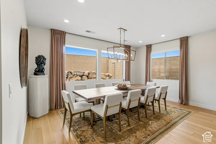 Recessed ceiling lighting, wood-finish flooring, and a contemporary chandelier