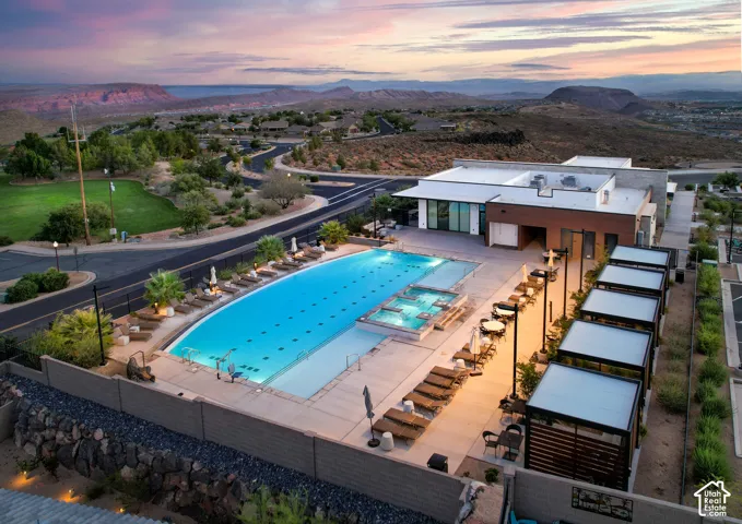 Expansive outdoor pool with integrated spa, adjacent to a contemporary building with large windows