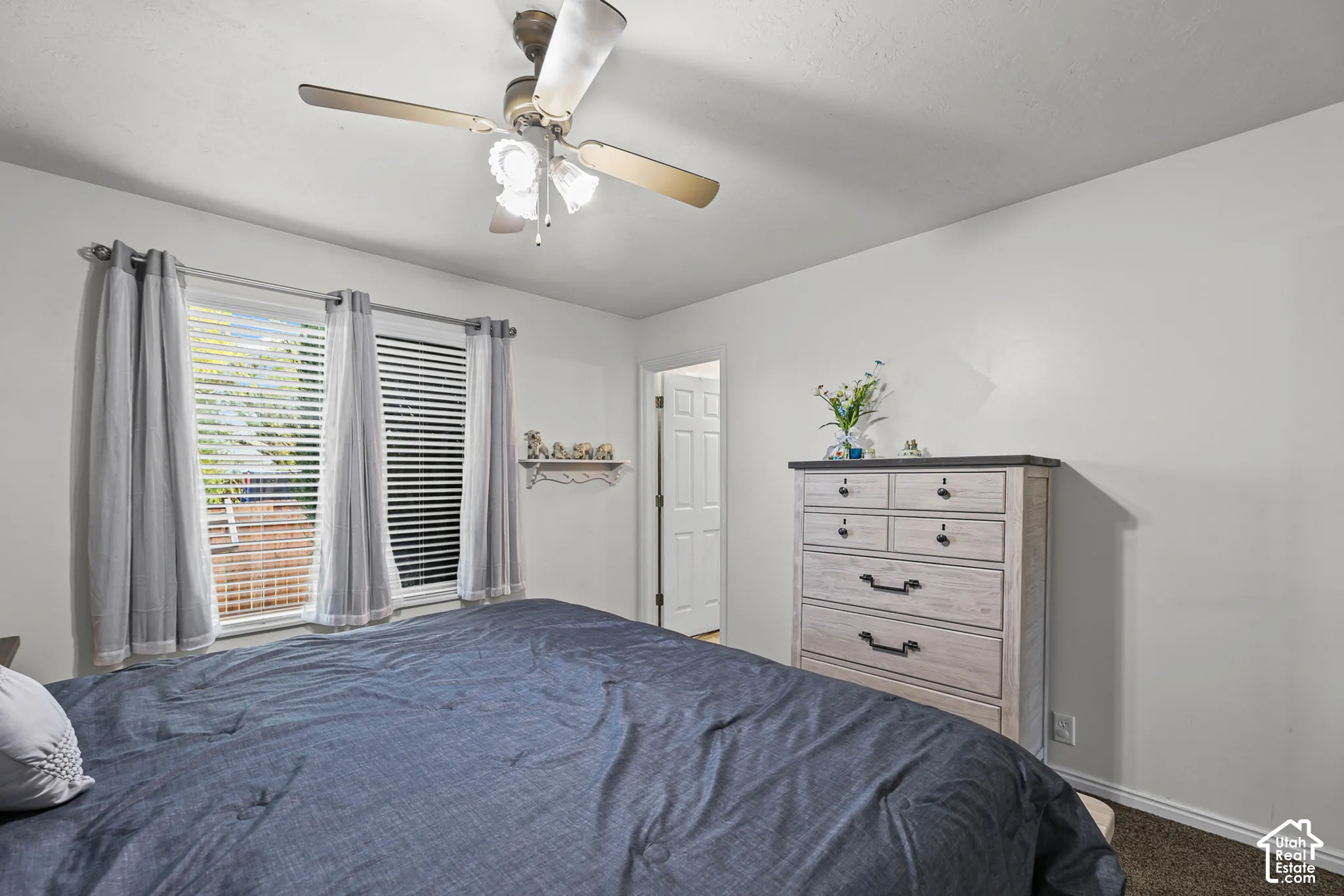 Recessed windows with blinds, ceiling fan with integrated lighting, door with paneling, and neutral wall tones