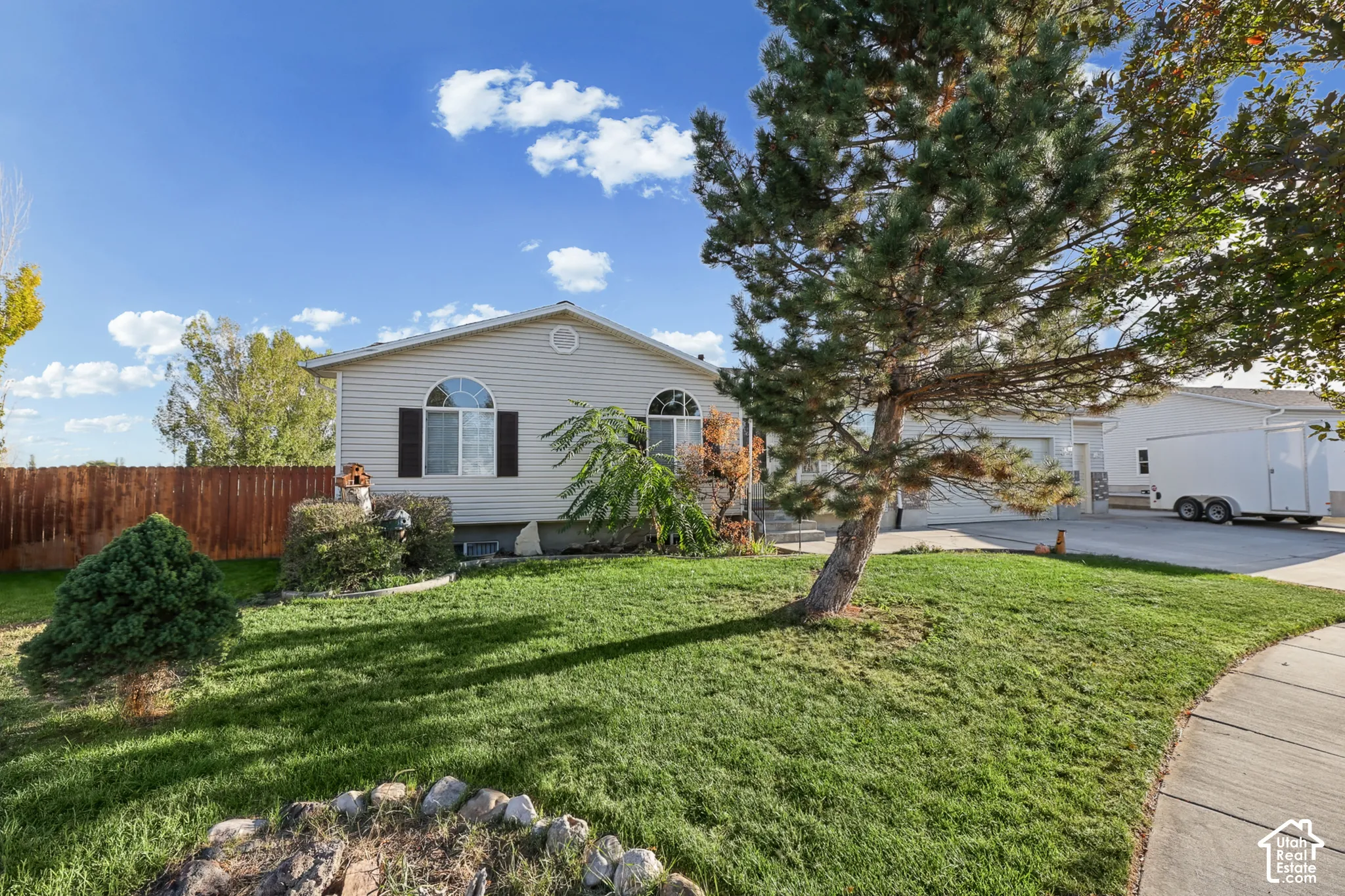 Single-story property with light-colored siding, a front lawn, and established landscaping