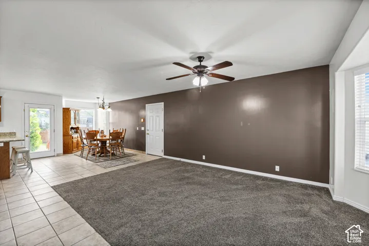 Carpeted main living area with a ceiling fan, recessed lighting, and a window with blinds