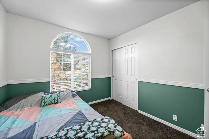 Arch-top window with blinds, bi-fold closet doors, and wall trim
