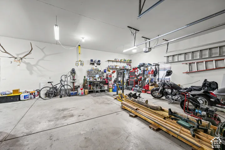 Spacious garage with concrete flooring, overhead lighting, and white walls