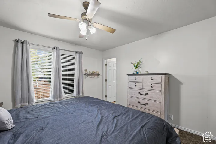 Recessed windows with blinds, ceiling fan with integrated lighting, door with paneling, and neutral wall tones