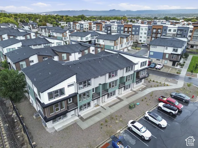 Modern townhome community featuring diverse architectural designs, pitched dark roofs, and multi-story elevations