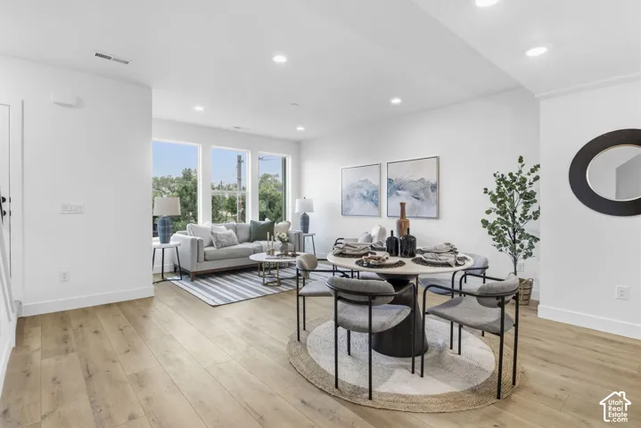 Open-concept living space featuring wood-finish flooring, recessed lighting, and large windows