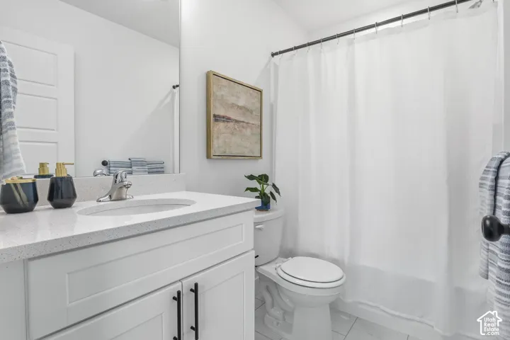 White shaker vanity with black hardware, integrated sink, and speckled countertop