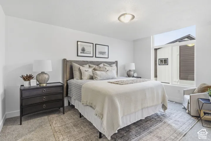 Recessed ceiling lighting, flat white walls, wall-to-wall carpeting, and a large picture window