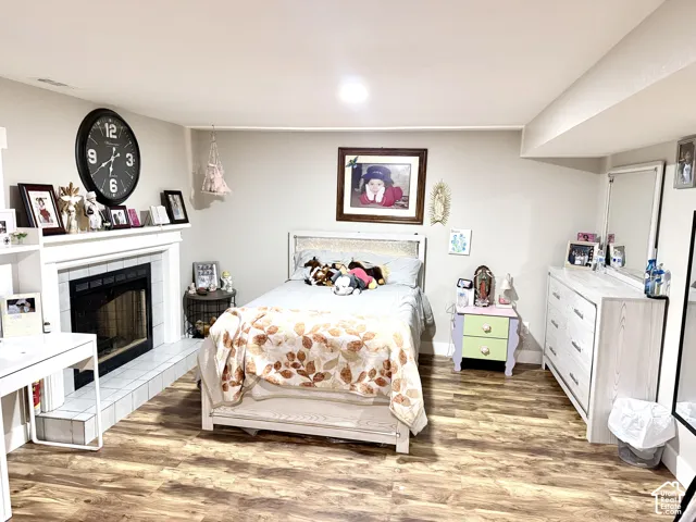 Wood-finish flooring throughout, featuring a built-in fireplace with a tile hearth and white mantel