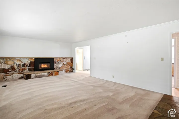 Stone-clad fireplace with a built-in hearth, black insert, and wood mantel