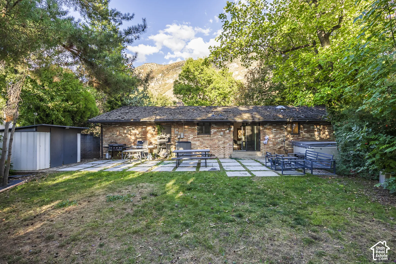 Brick exterior with a shingle roof and sliding glass door