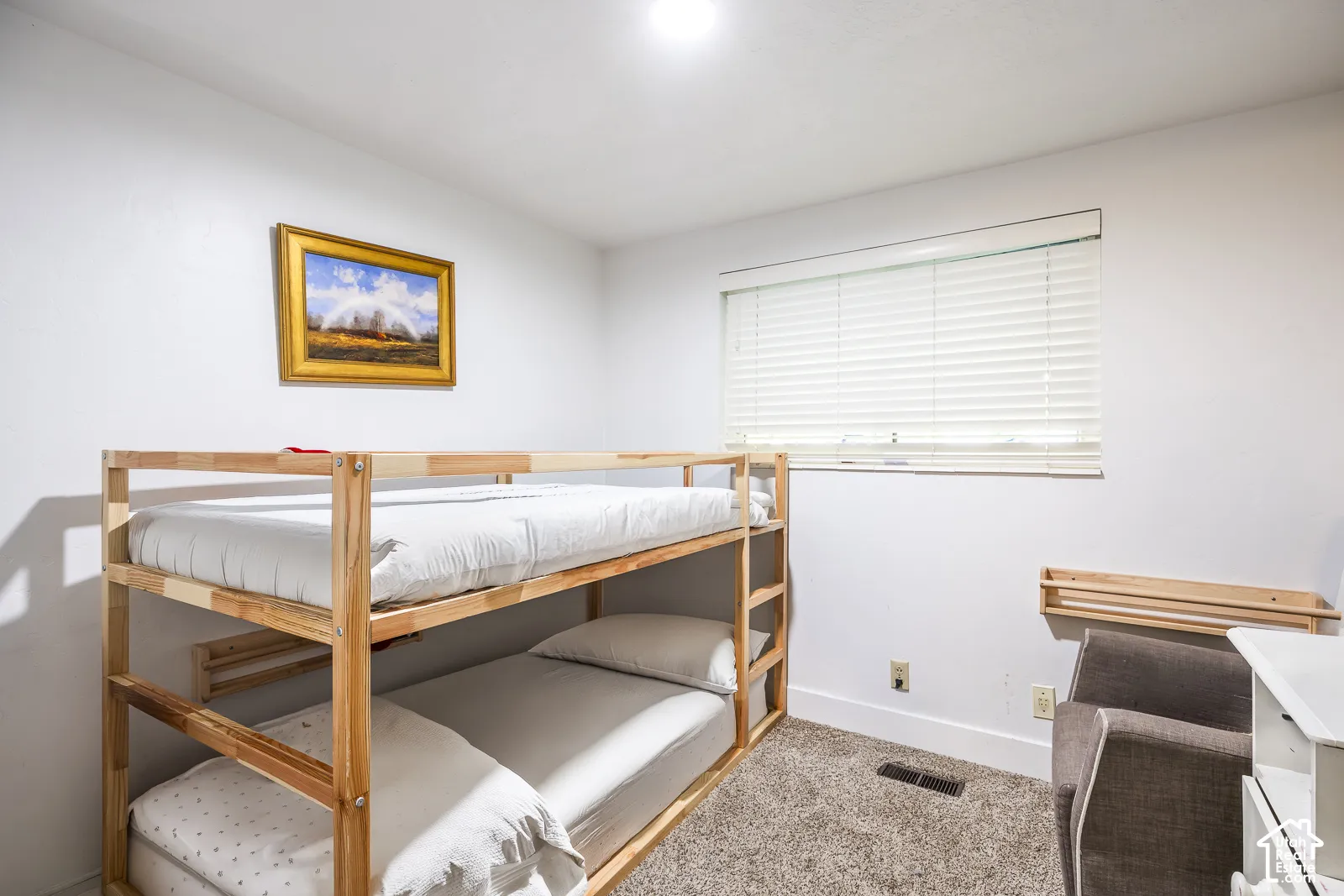 Carpeted room featuring bunk beds, a window with blinds, and white walls