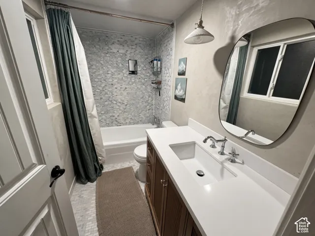 Bathroom with a white tub, mosaic tile surround, white rectangular sink, chrome fixtures, and a wood-finish vanity
