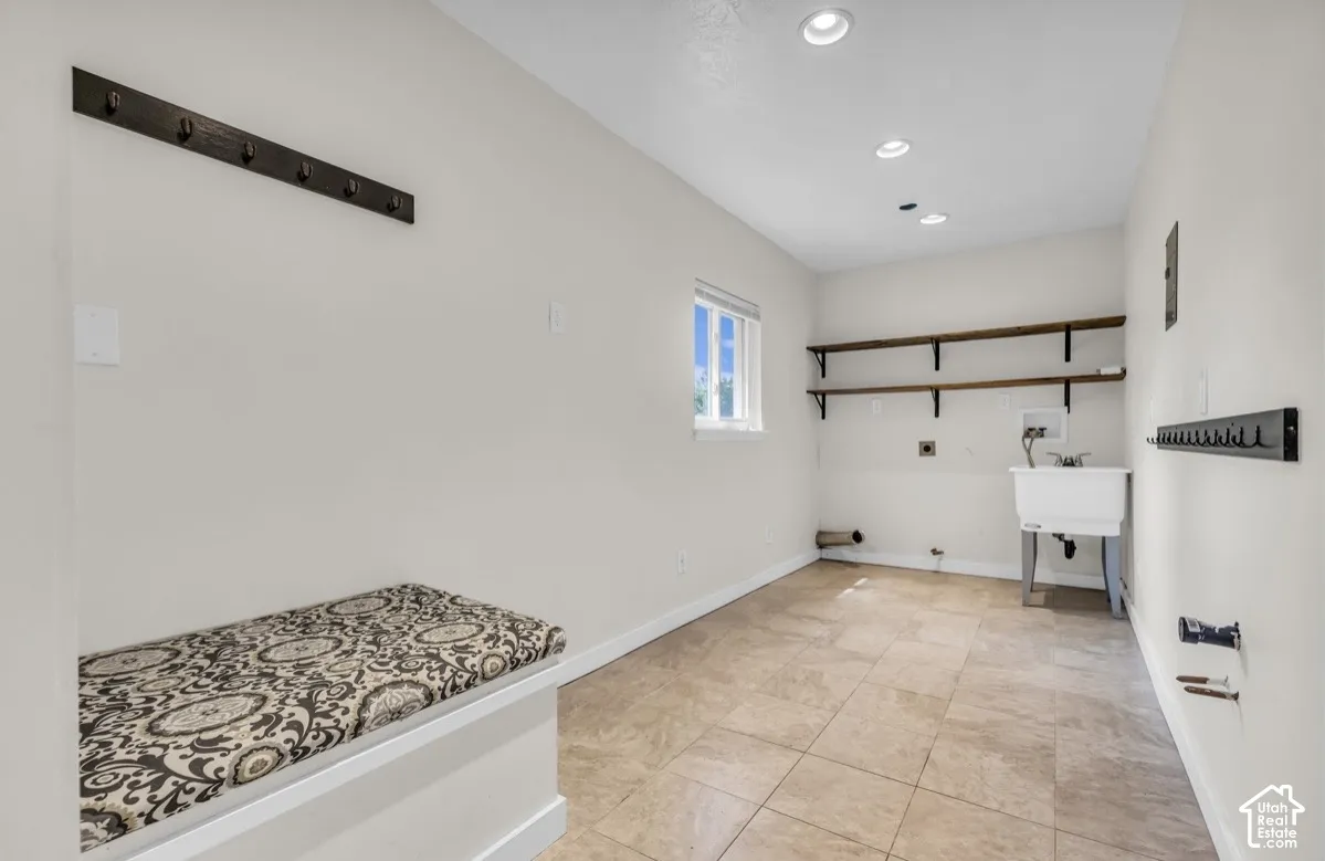 Laundry area featuring tiled flooring, recessed lighting, and a utility sink