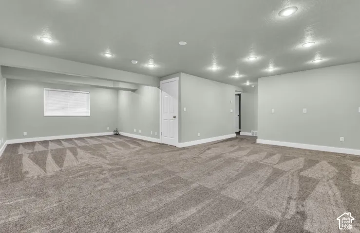 Generous room featuring recessed lighting, a window with blinds, and durable carpeting