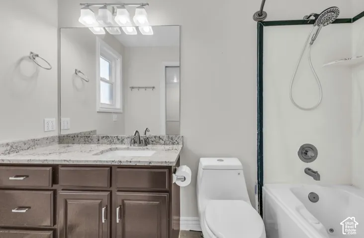 Vanity with granite-style countertop, integrated sink, and dark wood-finish cabinetry
