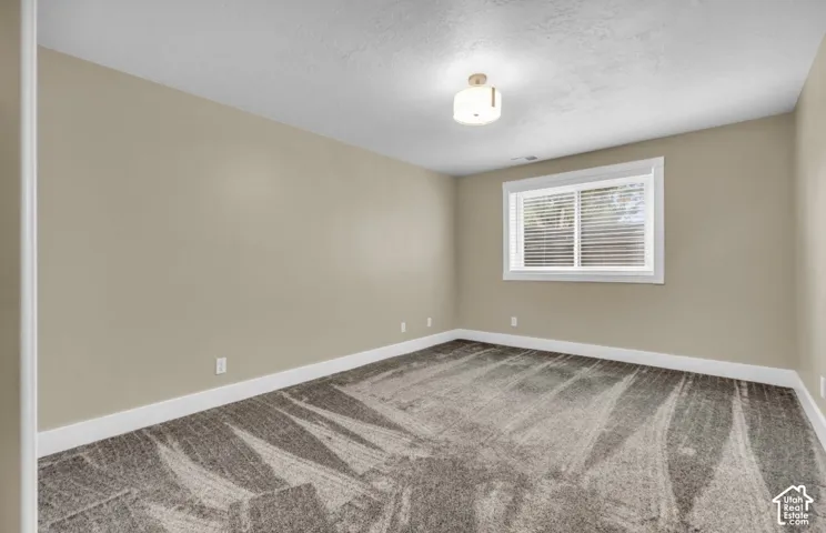 Neutral-toned walls complement the patterned carpet flooring