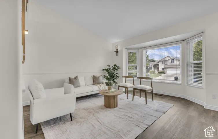 Hard-surface flooring, bay window, wainscoting, and a wall-mounted light fixture
