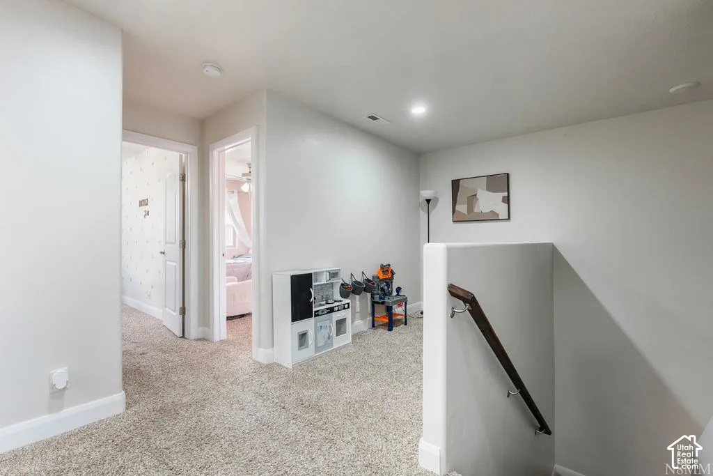 Recessed ceiling lighting, light-colored carpeting, white walls, and white trim