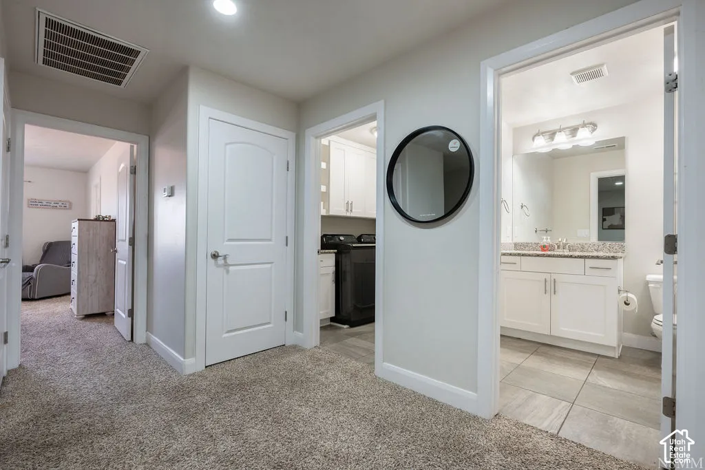 Hallway featuring carpet flooring and multiple doorways