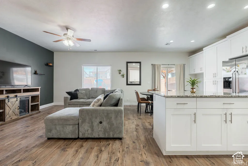 Open-concept living area featuring wood-finish flooring, recessed lighting, and a ceiling fan