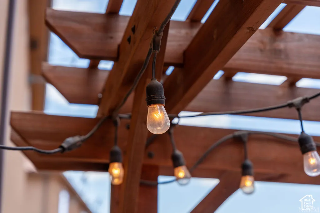 Wooden pergola featuring exposed beams and string lighting