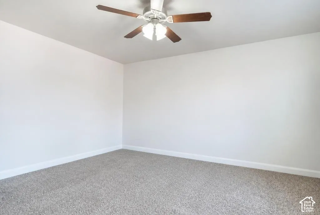 Neutral-toned walls with ceiling fan and light fixture