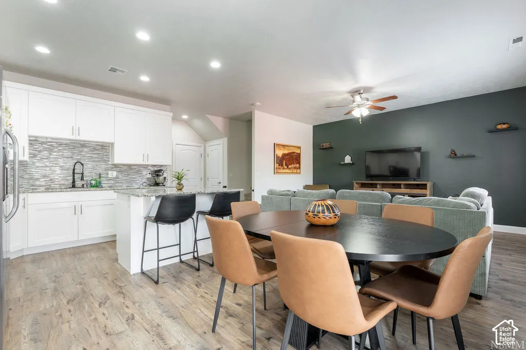 Open-concept living area with wood-finish flooring, recessed lighting, and a ceiling fan