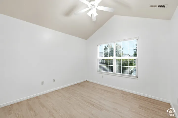 Vaulted ceiling, wood-finish flooring, white walls, double-pane window with blinds, and a ceiling fan