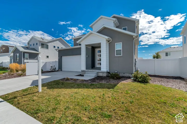 Contemporary exterior with a covered entry, attached garage, and white perimeter fencing
