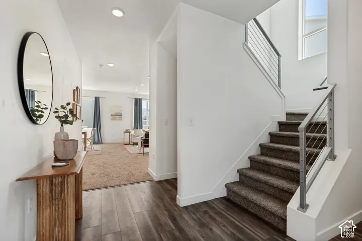 Wood-finish flooring, recessed lighting, and a modern staircase with cable railing