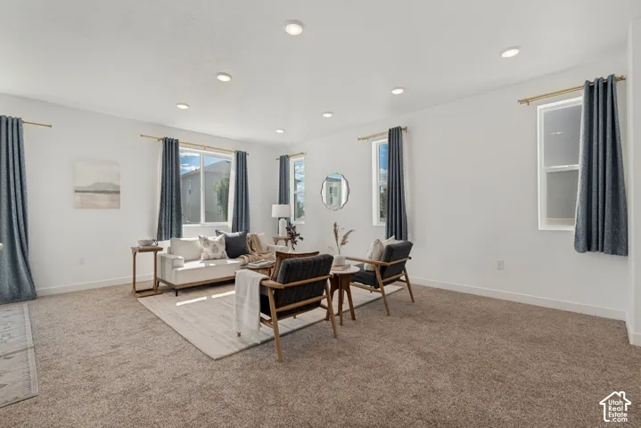 Recessed lighting illuminates the carpeted floor and white walls