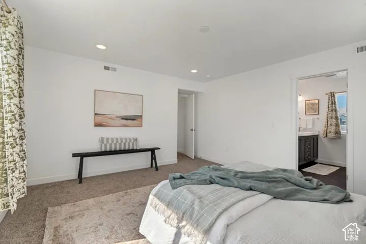 Carpeted flooring, recessed lighting, white walls, built-in vanity with a sink, and pendant lighting