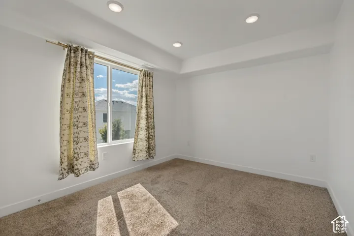 Recessed lighting, neutral wall finishes, and a single window