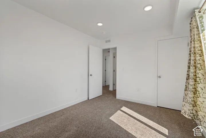 Recessed lighting, white walls, carpeted flooring, and white interior doors