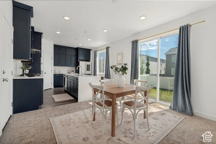 Kitchen featuring dark cabinetry, white countertops, a center island, and wood-finish flooring