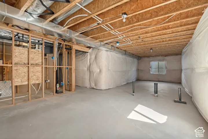 Unfinished basement with concrete flooring and exposed ceiling joists
