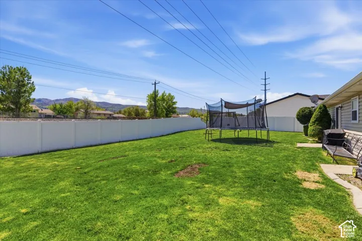 Expansive grassy yard enclosed by a white privacy fence