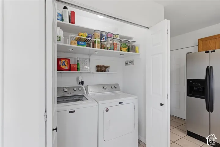 Dedicated laundry area with built-in shelving, overhead lighting, and white bi-fold doors