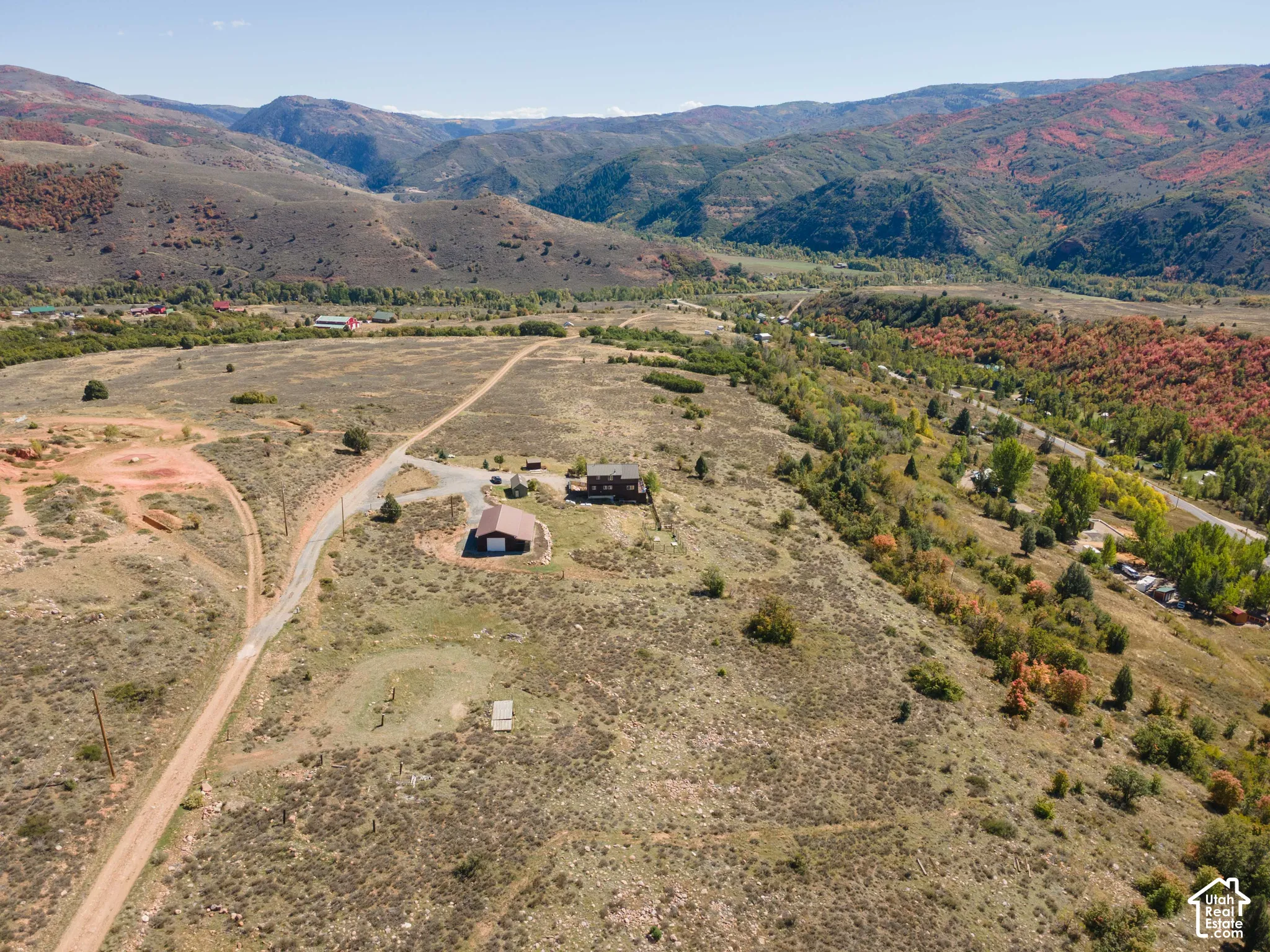Expansive property featuring a residence, detached structure, and a mountainous backdrop